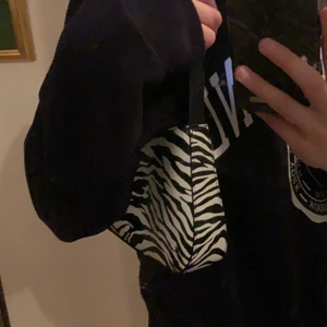 Väska - Säljer nu denna super fina väska med zebra mönster! Nyskick! Säljer för att jag inte gillar den så mycket längre, den har ett inre fack som är super bra, bandet går att skystera! Köpt för inte alls länge sen