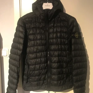 Stone Island dunjacka svart  - Svart stone island dunjacka perfekt vår/höst jacka.      Jackan är storlek S/M.                                                       Väldigt sparsamt använd, knappt använd.                         Köpt i NK Stockholm. Nypris 5000kr. 