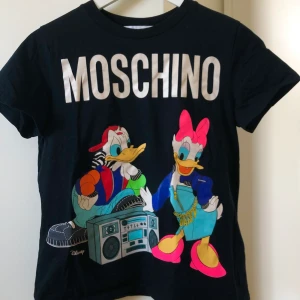 Moschino t-shirt  - Supersnygg T-shirt från Moschino x H&M i mycket bra skick. Säljer pga att jag vill byta ut signaturplagg.