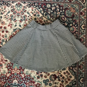 Svartvit kjol - Ish rutig? Faller väldigt snyggt och har resor i midjan så är hyfsat justerbar. Använd för många år sen men då endast ett fåtal gånger. Kort! 