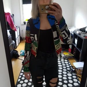  - Jacka som är mönstrad i flera olika färger. Den är ganska kort i längden. Den var lite för tight för mig över brösten, så den kan säkert passa en XS också. Köparen står för frakt. OBS, katt i hemmet.