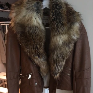  - Fakepäls, storlek 34. Söm som gått upp lite på insidan i armvecket annars bra skick! Pälsen går att ta av