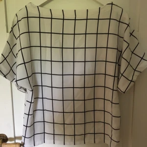  - Vit t-shirt med svarta rutor. Ganska lös passform så storlek är lite svår att bestämma. Kan mötas upp i Malmö/Trelleborg, annars betalar köparen frakt. 