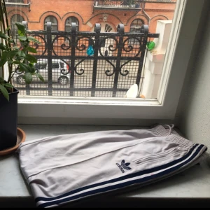  - OVANLIGA skitsnygga addidasbyxor a la "sporty spice"! Direkt från 90-talet i ljusgrått och blått silke !  Med fickor och justerbar midja!  🍦🍦