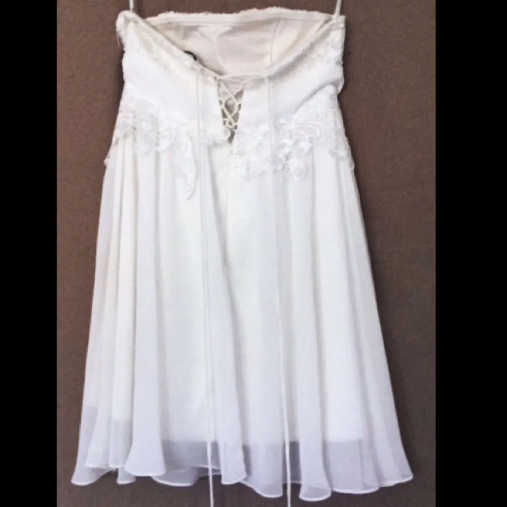  En vit spetsklänning men snygg snörning i ryggen, den är axelbandslös , den är endast använd på en skolavslutning.  Nypris 1200kr Vid snabb affär så kan priset diskuteras  . Klänningar.