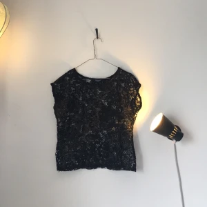  - Blommig, transparent top med lite guldigt i tyget. 