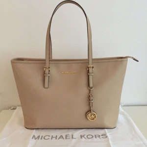  - Säljer min i princip oanvända Michael Kors väska som jag köpt på nelly.com i somras. Nypris 3200kr. Den mäter: Bredd 48 cm. Höjd 29 cm. Djup 16 cm och har ett fack för labtop i mitten. Väldigt rymlig väska och en snygg beige färg. Tyvärr kändes den inte rätt för mig men jag hoppas att den kan komma till användning hos en ny ägare! Endast seriösa bud! Möts helst upp annars tillkommer frakt. 🌸 dustbag medföljer. 