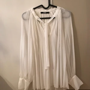  - Vit blus, använd endast en gång. 