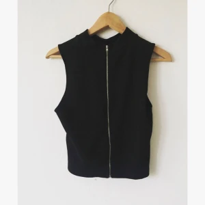 - Svart, cropped top med polokrage och dragkedja i ryggen. Storlek large. I bra skick. 