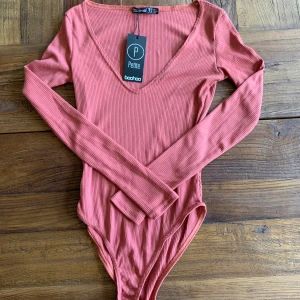 Ribbad body ifrån Boohoo - Jätte snygg ribbad mörkrosa body ifrån Boohoo som inte kommit till användning och är i fint skick 