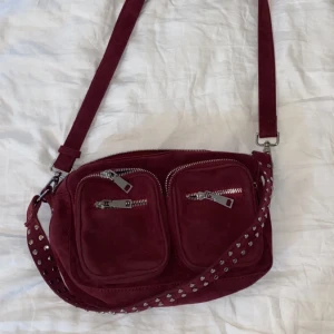 Väska från noella i vinröd  - Rymlig men ändå inte för stor väska från noella i en superfin vinröd färg! Kommer aldrig till användning tyvärr. Köpt för 649