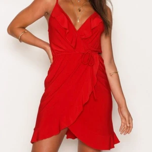 Oanvänd klänning - Röd omlottklänning från Nelly One. Lappen finns kvar. 