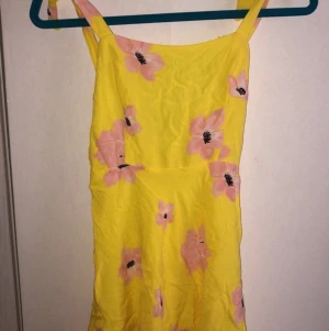 Zara Klänning  - Säljer denna gula sommarklänning med härliga blommor på från ZARA. Jag har bara använt den en gång så den är i prencip ny. (Köparen står dock för frakten)