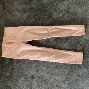Gulliga rosa jeans med hål på knäna