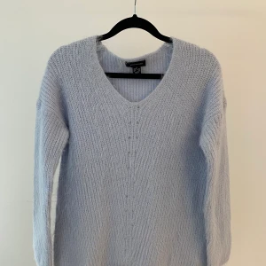 Ljusblå stickad tröja  - Fluffig stickad tröja i fin ljusblå färg. Otroligt len mot huden, ej sticksig. I nyskick. Storlek 36/S men skulle säga att den säga att den också passar en 38.