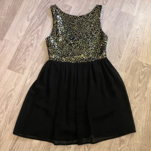 Festklänning  - Festklänning med guldiga paljetter, strl 38 men skulle passa en 36:a också. 
