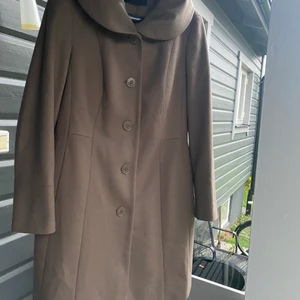 ESPRIT Kappa 42-44 - OANVÄND! Lätt formsydd och stor härlig krage som man både kan ha liggande och ”mjukt stående”... 80% Ull.  Färg = Beige-Grå  L = 91 cm Ärm = 64 cm Nypris: 1 700 :-  Hittar ingen storlek men skulle gissa på 42-44 eller L - XL