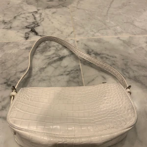 Nelly väska - Vit väska i krocko från Nelly, väldigt fint skick, sparsamt använd
