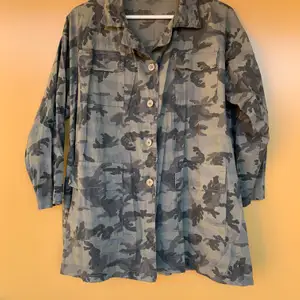 Skjorta i kamouflage med tryck på ryggen. Köpt på en lokal affär med italiensk design. Strl känns som M/L. Frakten står köparen för.