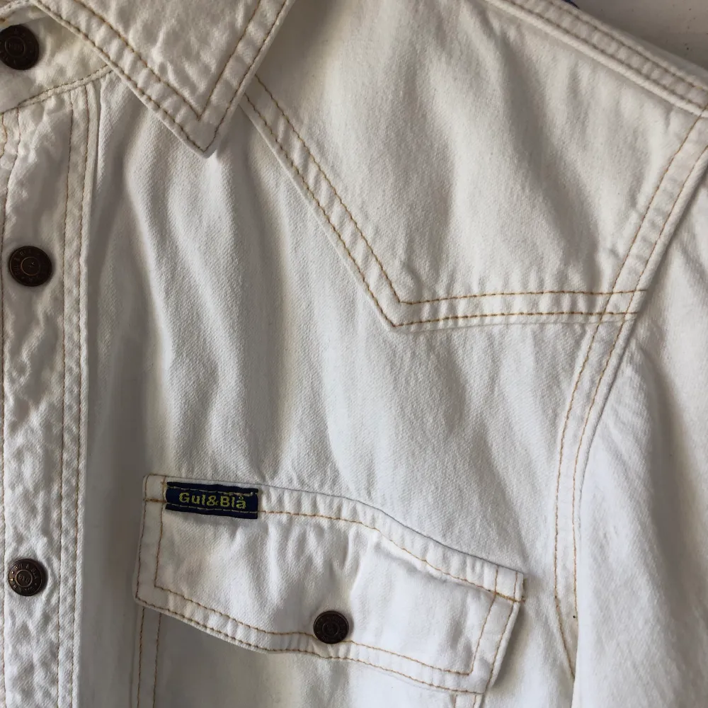 En vit jeansskjorta från Gul & Blå. Köpt vintage men aldrig använd av mig - i toppen skick! Storlek S. 150kr, om den ska skickas tillkommer frakt på 63kr. Kan mötas i Telefonplan/Mariatorget. . Skjortor.