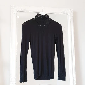 Svårt tröja Studio S - Färg: svart.  Strl: S.   Fin svart tröja av märket Studio. Använd vid ett tillfälle, mycket fint skick.  Detaljer av spetts uppe vid halsen, samt ärmslut. Slimmad modell.  Kommer ej till användning & stor garderobsrensning pågår! Frakt tillkommer, swish!