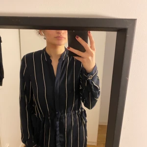 Lång skjortklänning  - Lång skjortklänning med öppningar på sidan. Storlek 34/36