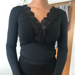 Långärmad top - Hej, säljer en långärmad topp med spetsdetaljer vid v ringningen. 