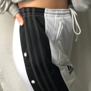Adidas Track Pants✨ - Vintage Adidas! Köpt secondhand. Använda men i bra skick. Vissa knappar på sidan har förlorat lite färg(märks inte mycket). De är lite genomskinliga som de flesta vita byxor. storlekslappen är borta men storlek kan va allt från XS till M, justerbar midja.