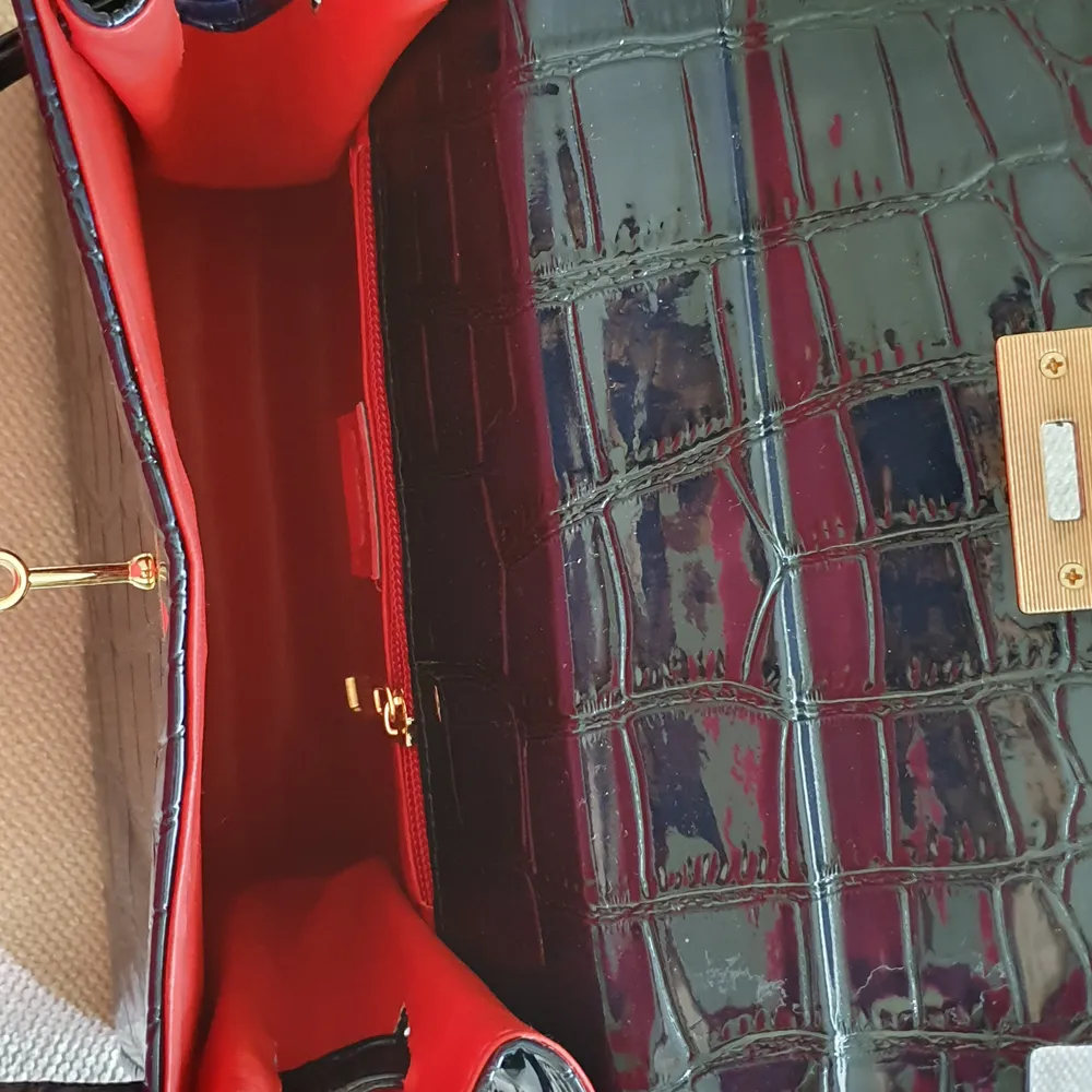 Marinblå handväska (ej äkta läder/skinn) med röd insida. Aldrig använd! . Väskor.
