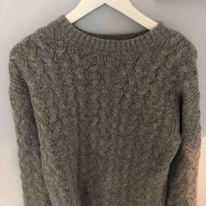  - Grå kabelstickad tröja från HM i bra skick. Köparen står för frakt!