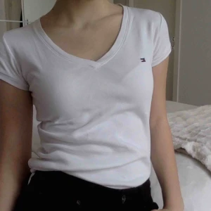  - Vit t-shirt med röda detaljer på ärmarna. Lätt att matcha. Träffas i centrala stockholm. 