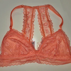Victorias Secret spets BH utan bygel str - Fin spets bh från VS i fin korall färg. Utan bygel och aldrig använd prislappen sitter kvar🥰