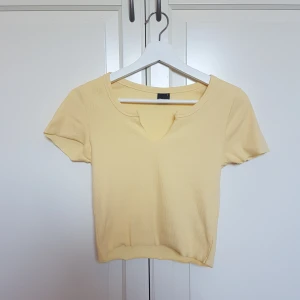 Gul kortare t-shirt utan kantsöm - Perfekt sommartröja, lite kortare, som är finribbad och utan söm längs kanterna. Har en liten fin ringning fram. Aldrig använd 🌼 köpare står för frakt!