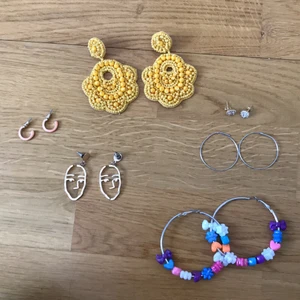 6 diverse örhängen - Alla sex par örhängen för 50kr. De gula från Indiska. ”Diamant”-liknande samt ansiktsörhängena är från Ur & Penn. Aprikosfärgade från Gekås. Silverringarna är från Brandy Melville. De stora ringarna med pärlor har jag trätt på själv.
