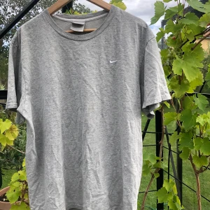 Vintage Nike  - Grå vintage Nike i bra skick!XL men inte överdrivet stort funkar bäst som en oversized T. Kan postas eller mötas upp i Stockholm! (OBS En reva i nacken titta vänster sida)