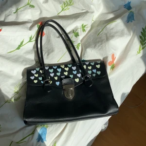 Väska svart - En second hand väska som jag sjölv valt att pimpa med akrylfärg. Har tyvärr inte användt men letar efter någon som hellre skulle vilja ha den! Färgerna på hjärtanen är lila, gul, grön och blått i pastell🌸💝🍭