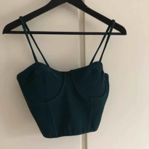  - Snyggt linne i mörkgrön färg, med ”BH” på utsidan,i kort modell