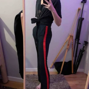  - Skitsnygga mörkblåa kostymbyxor med röda streck på sidorna. Storlek xs/34 men passar både XS/Small. Jag är 175cm och inte för korta för mig om jag har de strax under midjan. 