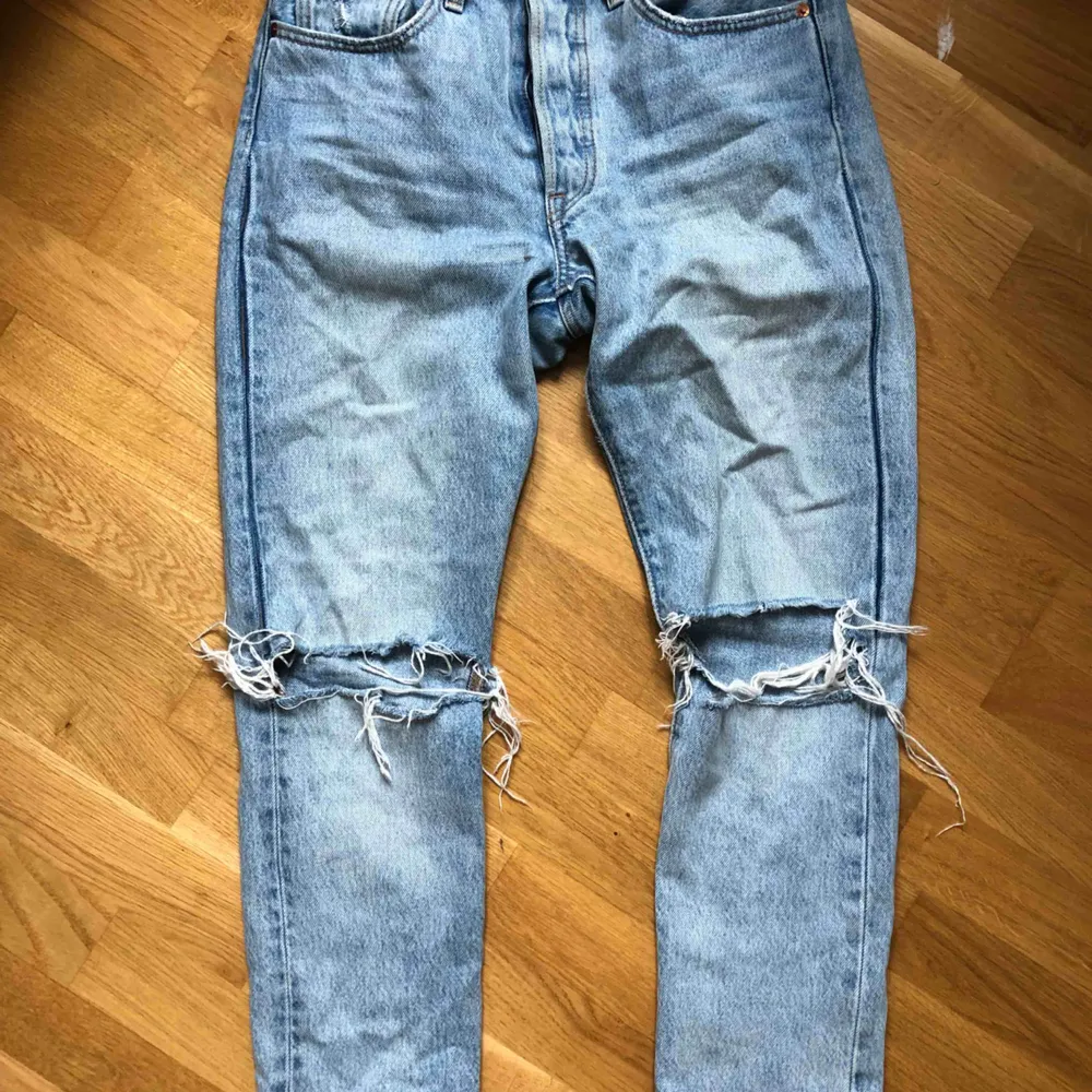 ljusblå jeans från Levis i W26/L28, hål på båda knäna, tighta vid rumpan mer pösiga nere vid vaderna. Sparsamt använda. Jeans & Byxor.