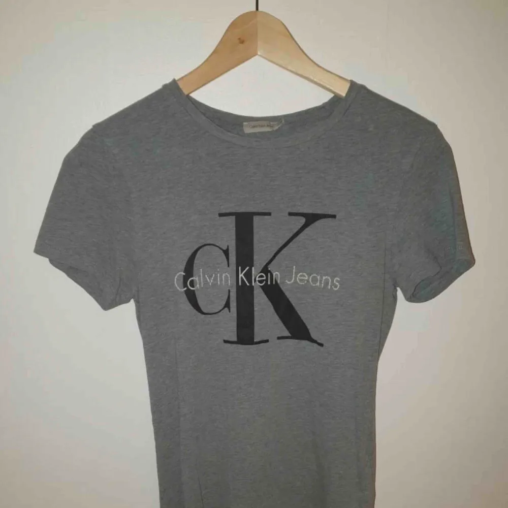 En klassisk Calvin Klein i grått. Väl använd, nytt pris 500 kr.. T-shirts.