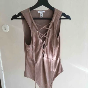  - Snörad body i mockaimitation. Jättefin brun färg. Tyvärr inte min stil längre! Möts upp i Uppsala eller fraktar mot betalning. 