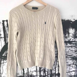  - Kabelstickad tröja i gräddvit kulör. Superfint skick och knappt använd, den enda skavanken är en liten mörkare missfärgning vid halsringningen, men syns inte förrän man tittar riktigt nära. Kan säkert gå bort med fläckborttagningsmedel. Frakt ingår! 🤩