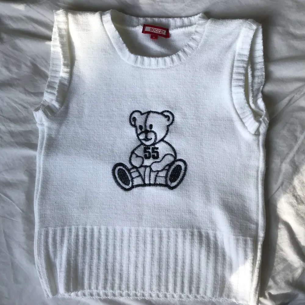 Trendig slipover / väst med en nalle broderad på framsidan! Aldrig använd :) Funkar att ha över t-shirts/långärmade tröjor eller bara som den är! Passar XS/S. Har även en i svart som finns utlagd på min sida, där kan du även se hur den sitter på! . Stickat.