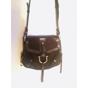  - Svart axelbandsväska från DKNY. Inneficka med dragkedja. Välanvänd och något sliten. 