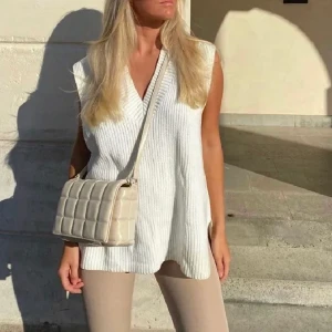 Väska - Beige/vit väska från nakd med justerbart band så du både kan ha den på axeln och över bröstet, aldrig använd.