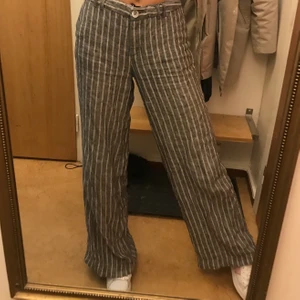 Vida kostymbyxor  - Grårandiga vida byxor! Fint skick och de har ett snöre man kan dra åt med i midjan. Passar personer i längd 172-180 skulle jag säga