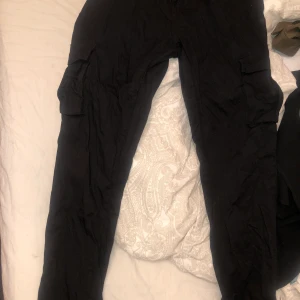 Svarta cargobyxor från madlay strl L - Inte använda många gånger så i bra skick, dem är stretchiga och har ett skönt tyg. Dem har samma färg som när jag köpte dem. Knappen på ena sidan är lite sönder men inget som märks förutom om man ska öppna den. Nypris 500kr, mitt pris 150kr+ eventuell frakt 