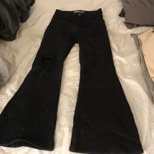 Svarta utsvängda jeans med håll i ena knät - Jeans ifrån Jamie fulare i från damark.