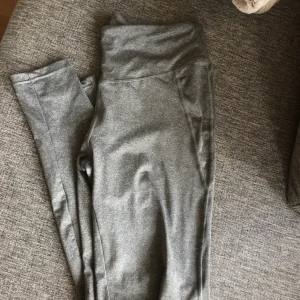  - Gråa högmidjade löpartights! Använda 1 gång, perfekt skick🌸 sitter super snyggt på kroppen! Säljes pga tyvärr blivit för stora