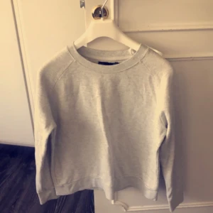  - Grå tröja med en liten detalj. Från lager 157. Storlek S. Pris: 30kr